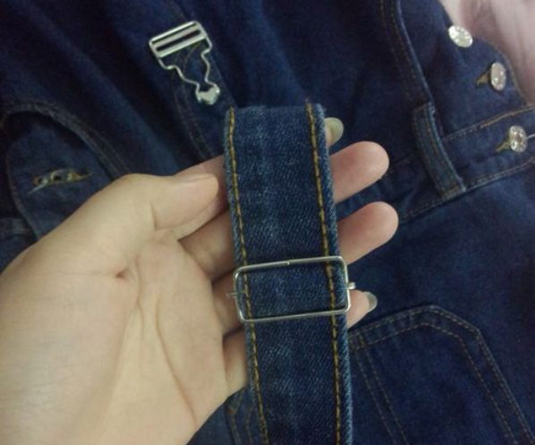 背帶褲的帶子先穿入方扣的孔中